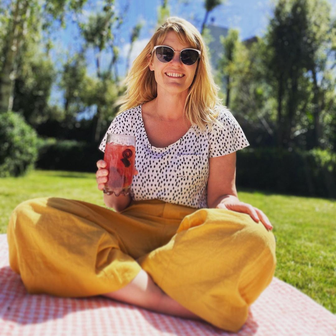 Amy sitting in the sun holding a glass of La Vie En Rose.