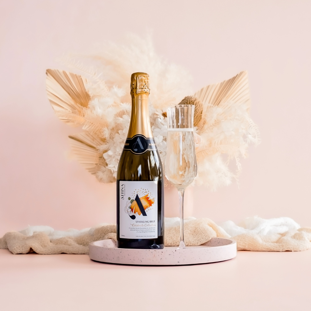 ALTINA Sparkling Brut – ALTINA’s non alcoholic sparkling wine bottle showcasing, alongside a poured glass showcasing the fine bubbles and golden hue of the sparkling wine. Perfect for celebratory moments and special occasions.