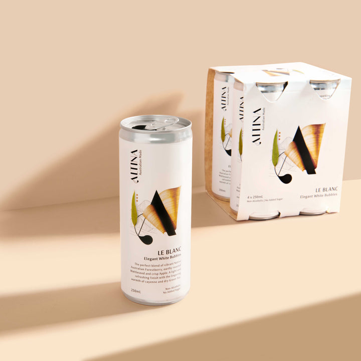 An Altina Le Blanc non-alcoholic canned white wine is shown in the foreground, with a Le Blanc four-pack carton positioned behind it on a neutral beige background.